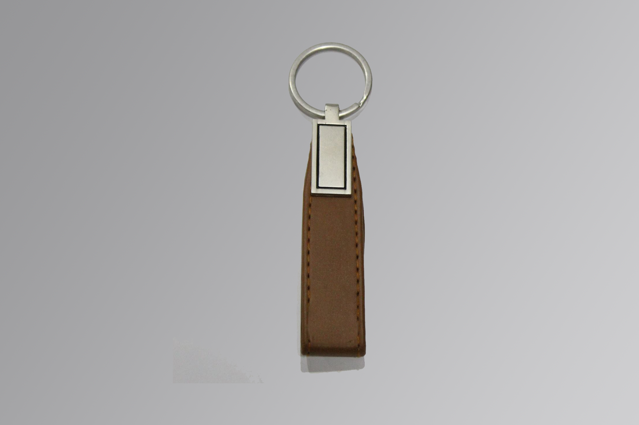 Handmade brown leather keychain with metal ring on white background