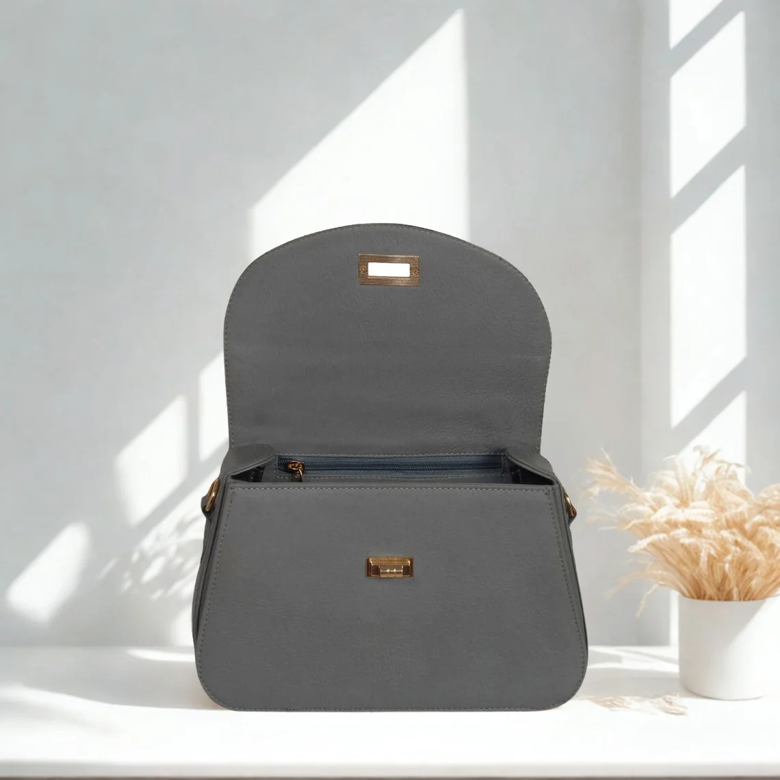 Leather Hill grey top-handle bag flap and gold-tone closure detail